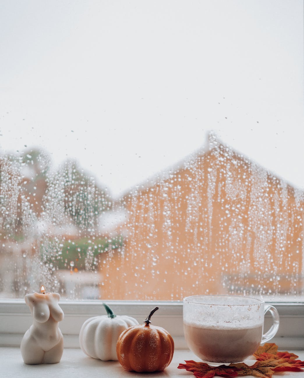 cup with coffee and candle on windowsill